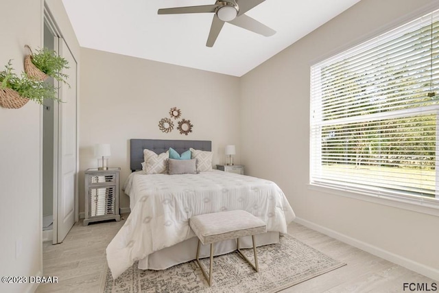 bedroom with multiple windows, ceiling fan, and light hardwood / wood-style floors