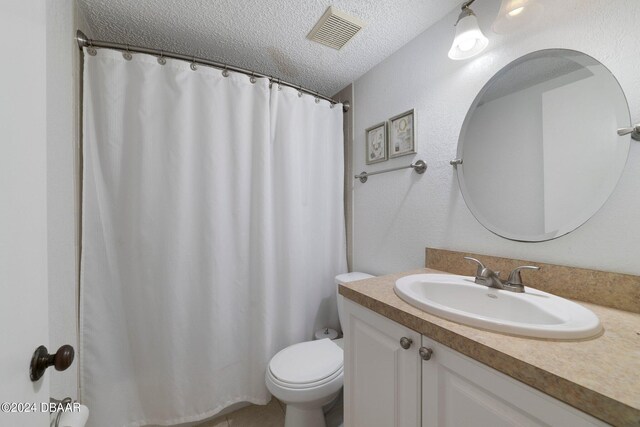 bathroom with vanity, a textured ceiling, and toilet