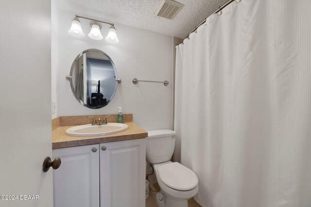 bathroom with vanity, a textured ceiling, and toilet