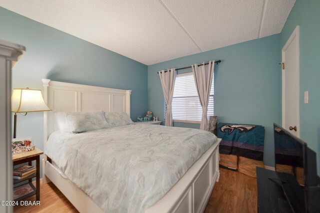 bedroom with light hardwood / wood-style flooring and lofted ceiling