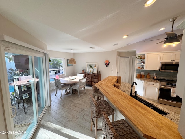 dining room with lofted ceiling, ceiling fan, and recessed lighting