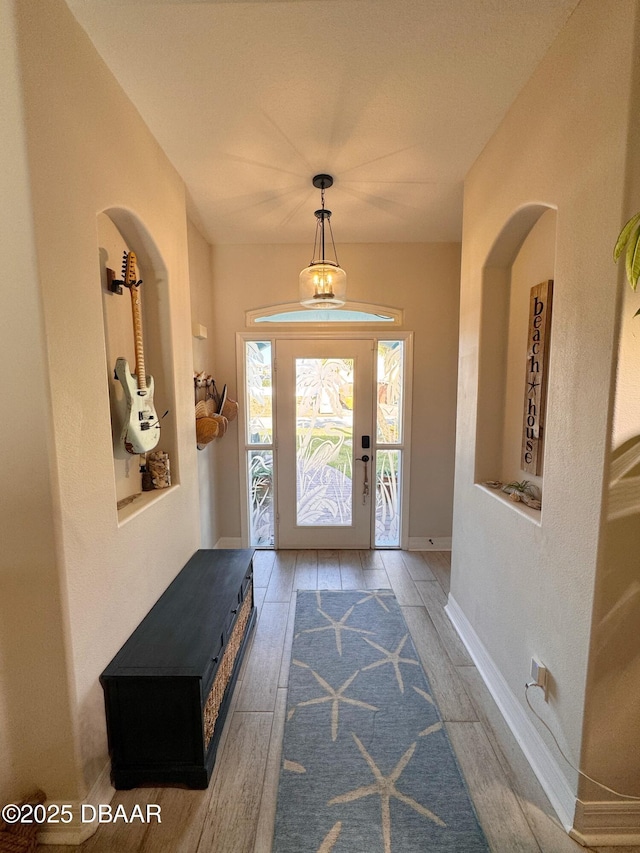 foyer with baseboards and wood finished floors