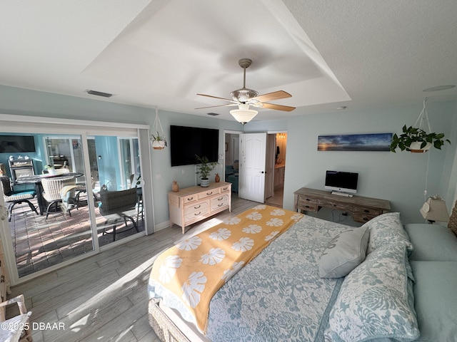 bedroom featuring baseboards, visible vents, a ceiling fan, access to outside, and light wood-type flooring