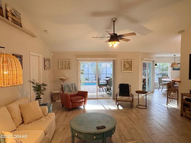 living room featuring lofted ceiling, ceiling fan, and light wood finished floors