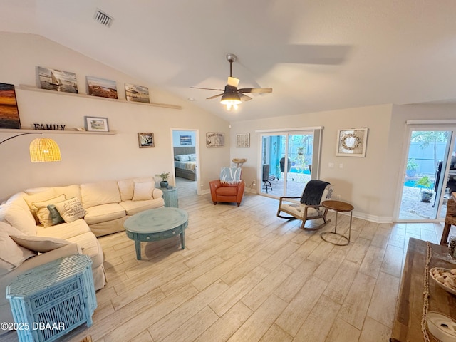 living area featuring light wood finished floors, plenty of natural light, visible vents, and vaulted ceiling