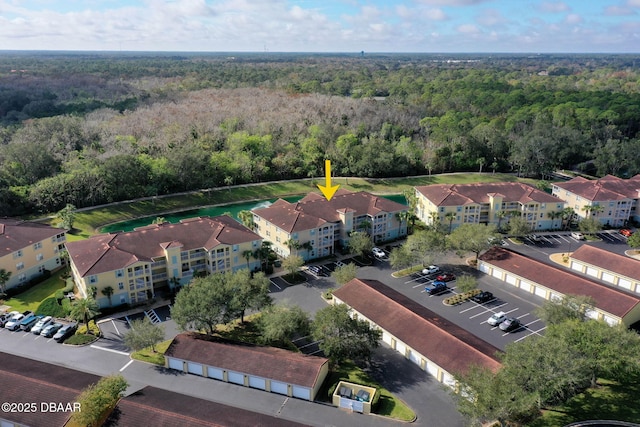 birds eye view of property featuring a view of trees