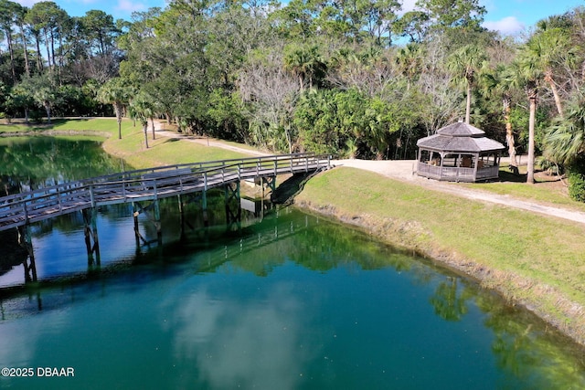 view of dock with a water view, a yard, and a gazebo