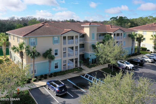 view of building exterior featuring uncovered parking and a residential view