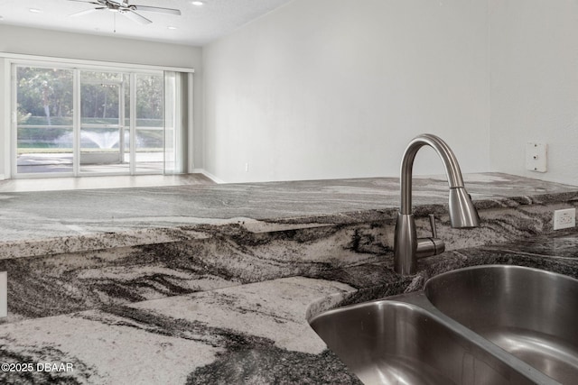 interior space featuring dark stone countertops, a sink, a ceiling fan, and recessed lighting