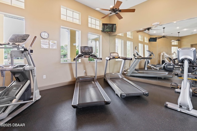 workout area featuring a ceiling fan and baseboards