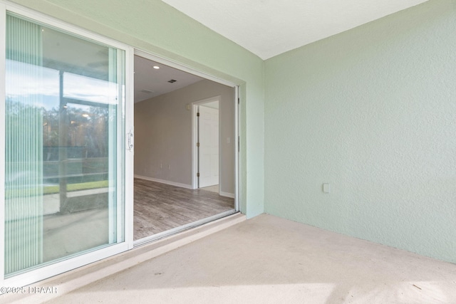 empty room with carpet and a textured wall