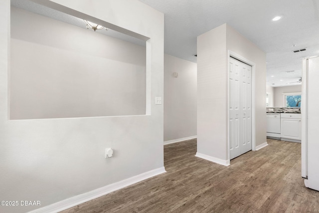 interior space with baseboards, wood finished floors, and recessed lighting