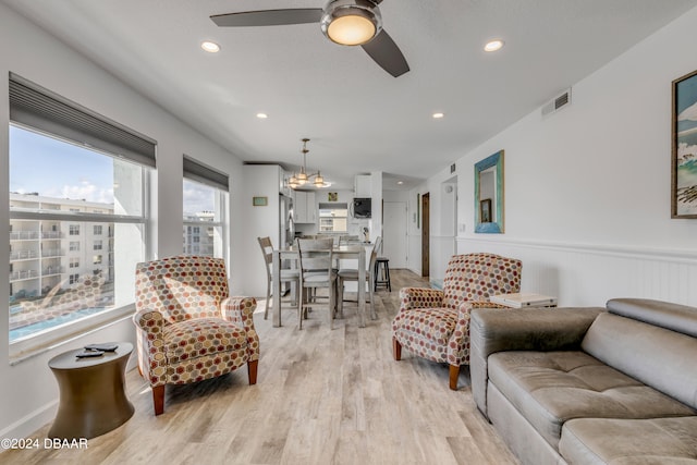 living room with light hardwood / wood-style floors and ceiling fan