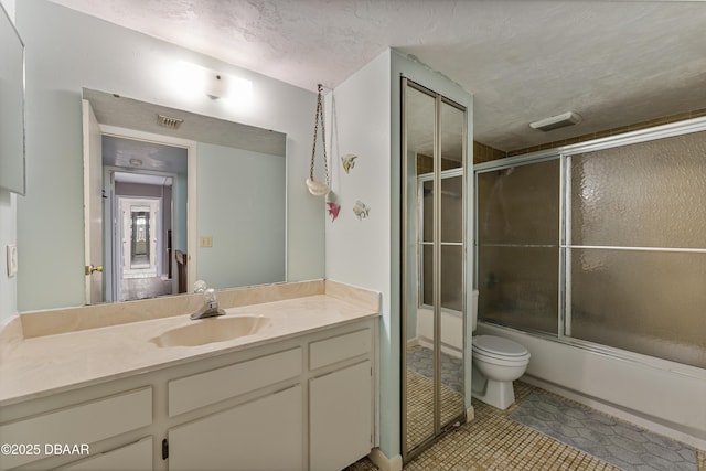 full bath featuring visible vents, toilet, vanity, combined bath / shower with glass door, and a textured ceiling