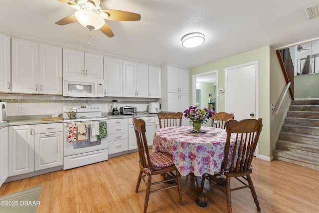 kitchen featuring white appliances, white cabinetry, and light wood-type flooring