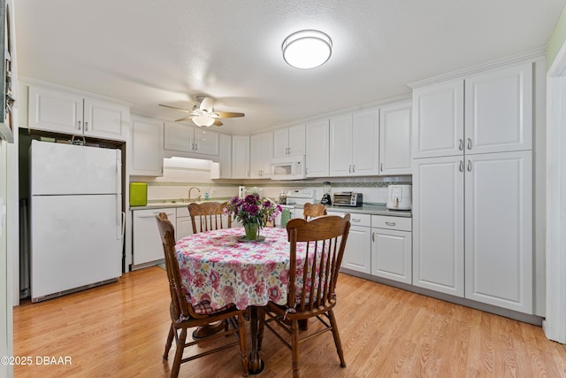 dining room featuring a toaster, light wood-style flooring, and ceiling fan