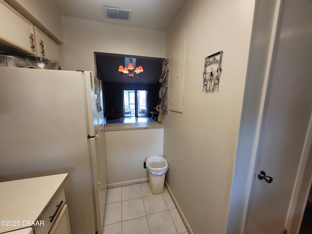 3557 Forest Branch Dr Unit B, Port Orange, FL 32129 - kitchen featuring freestanding refrigerator, light tile patterned floors, a chandelier, light countertops, and white cabinets