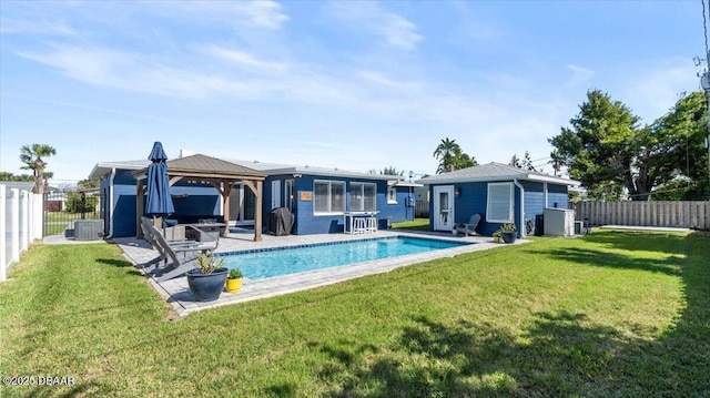 rear view of property with a gazebo, a yard, and a fenced backyard