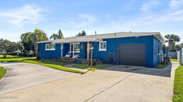 ranch-style home featuring a porch, a garage, fence, concrete driveway, and a front lawn