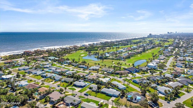 drone / aerial view with golf course view, a water view, and a residential view