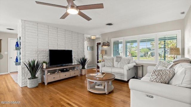 living area featuring light wood-type flooring, visible vents, and a ceiling fan