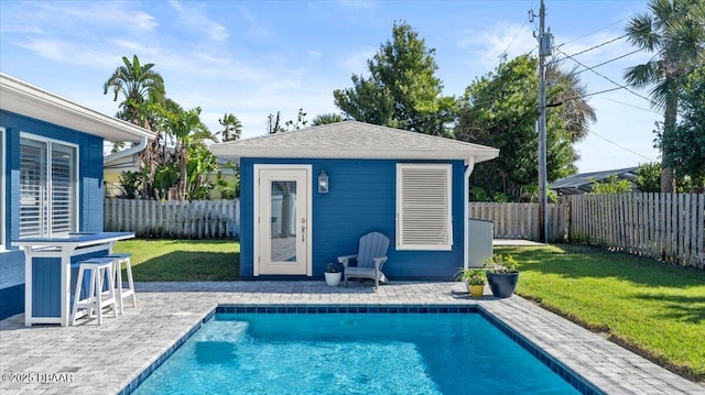 view of pool featuring a fenced in pool, a fenced backyard, an outdoor structure, and a lawn