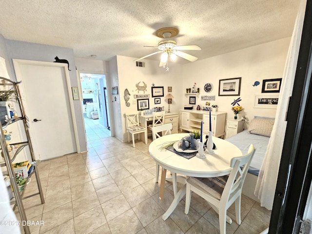 dining area with ceiling fan, a textured ceiling, and light tile patterned floors