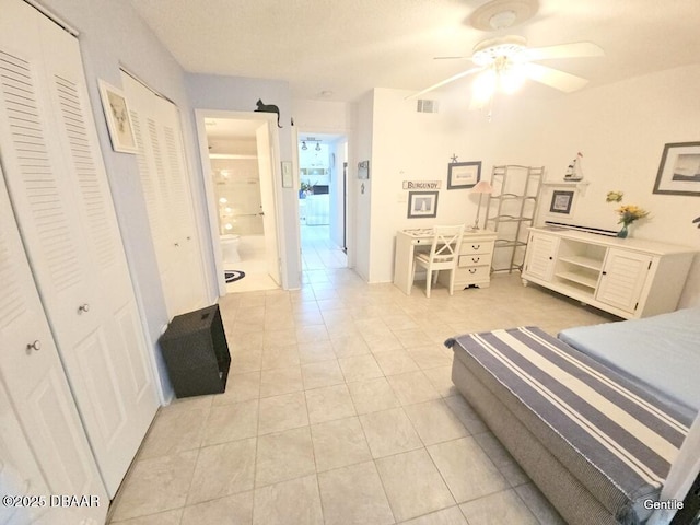 55 Chippingwood Ln, Ormond Beach, FL 32176 - bedroom featuring light tile patterned flooring, connected bathroom, two closets, and a ceiling fan