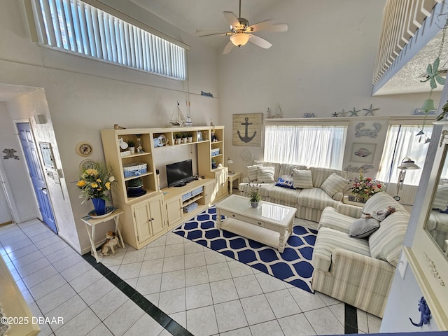 tiled living room featuring ceiling fan and a towering ceiling