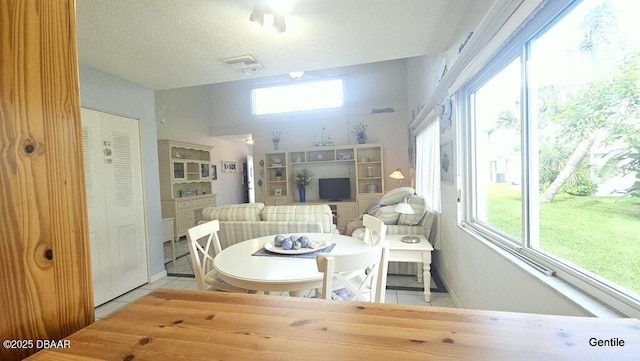 55 Chippingwood Ln, Ormond Beach, FL 32176 - dining space with healthy amount of natural light, light tile patterned floors, and a textured ceiling