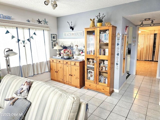 kitchen featuring ceiling fan, light tile patterned floors, and a textured ceiling