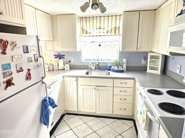 kitchen featuring ceiling fan, sink, white appliances, light tile patterned floors, and cream cabinets