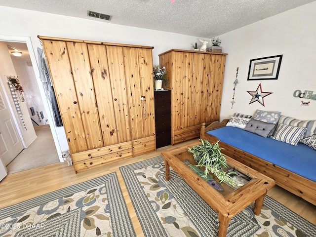 living room with a textured ceiling and wood-type flooring