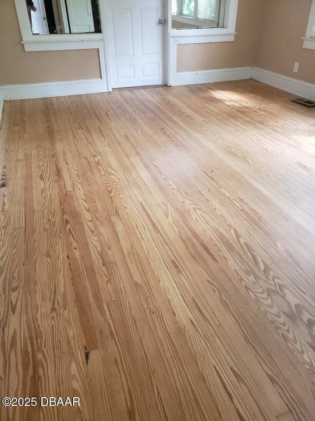 interior details with wood finished floors, visible vents, and baseboards