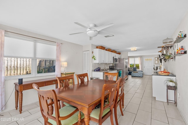 dining area with ceiling fan, sink, and light tile patterned floors