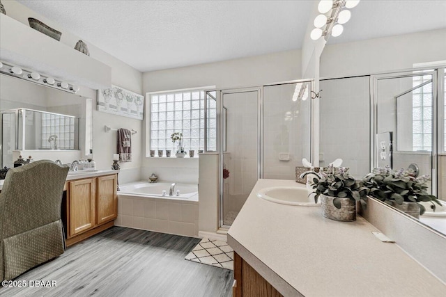 21 Whittingham Ln, Palm Coast, FL 32164 - bathroom featuring a shower stall, wood finished floors, a sink, a bath, and two vanities