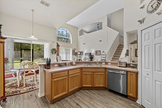 21 Whittingham Ln, Palm Coast, FL 32164 - kitchen with high vaulted ceiling, a sink, dishwasher, pendant lighting, and visible vents