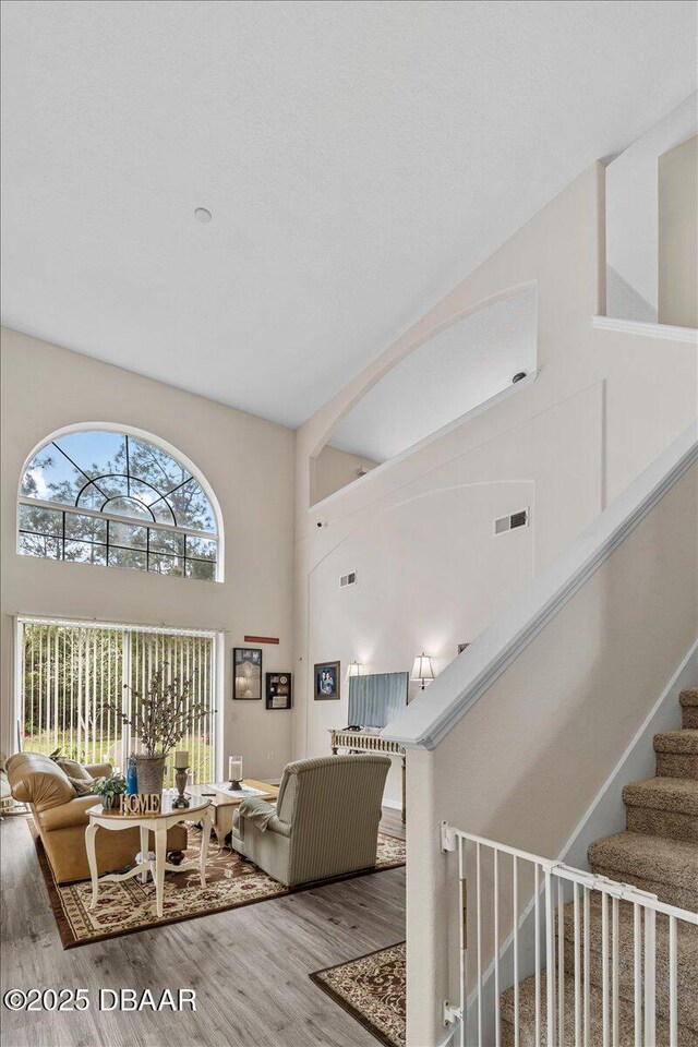 21 Whittingham Ln, Palm Coast, FL 32164 - living room with visible vents, wood finished floors, a high ceiling, and stairs