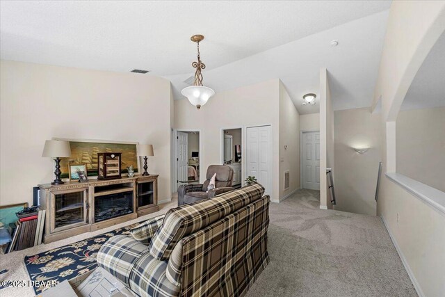 21 Whittingham Ln, Palm Coast, FL 32164 - living room featuring vaulted ceiling, arched walkways, baseboards, carpet flooring, and visible vents