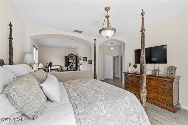 21 Whittingham Ln, Palm Coast, FL 32164 - bedroom with arched walkways, light wood-type flooring, visible vents, and baseboards