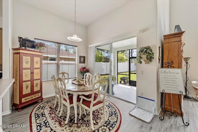 21 Whittingham Ln, Palm Coast, FL 32164 - dining space featuring baseboards, a towering ceiling, and light wood finished floors