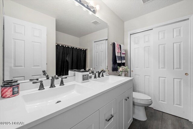 21 Whittingham Ln, Palm Coast, FL 32164 - bathroom featuring wood finished floors, visible vents, a sink, and toilet