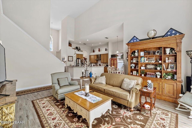 21 Whittingham Ln, Palm Coast, FL 32164 - living room with stairs, a towering ceiling, and light wood-style flooring