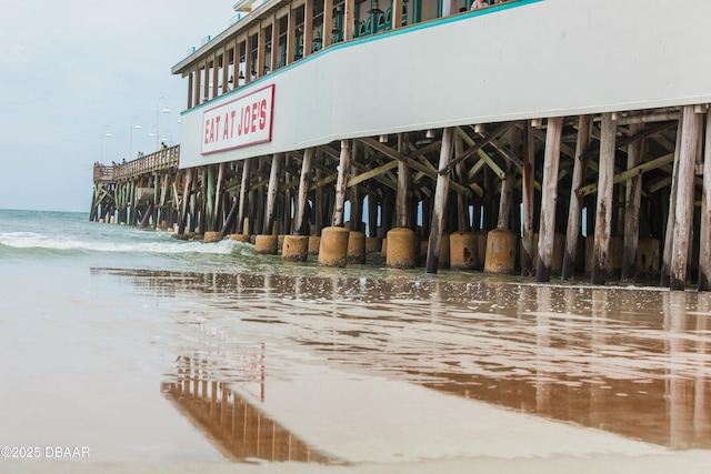 view of building exterior featuring a water view and a pier