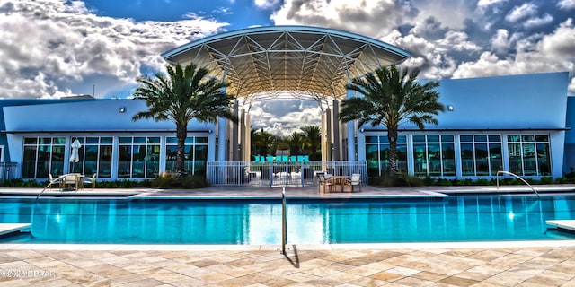 pool with a patio area and fence