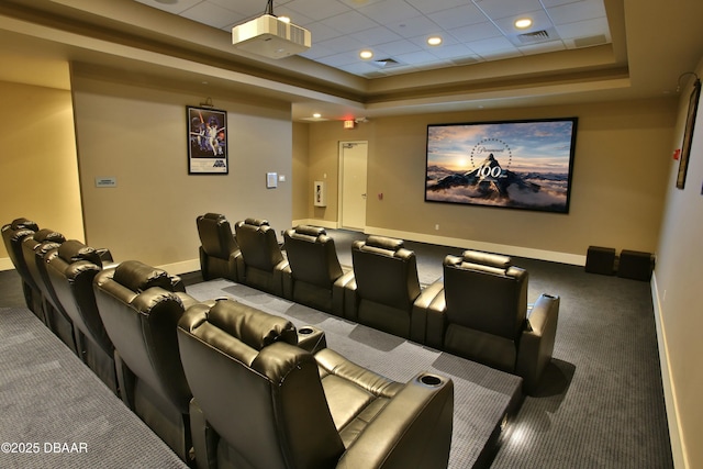 cinema with carpet floors, a tray ceiling, visible vents, and baseboards