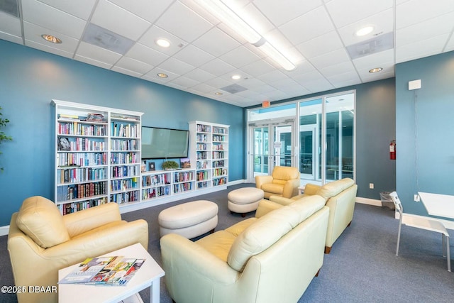 living area with recessed lighting, carpet, a drop ceiling, and baseboards