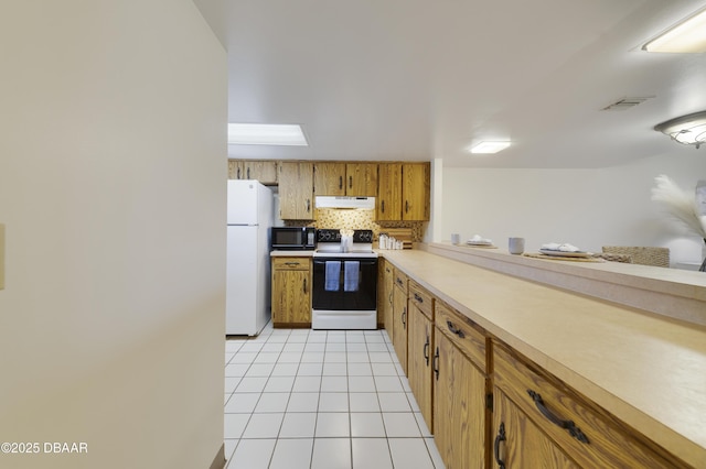 kitchen featuring white appliances, light tile patterned floors, visible vents, decorative backsplash, and under cabinet range hood