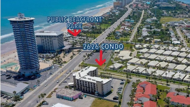 drone / aerial view with a view of city, a view of the beach, and a water view