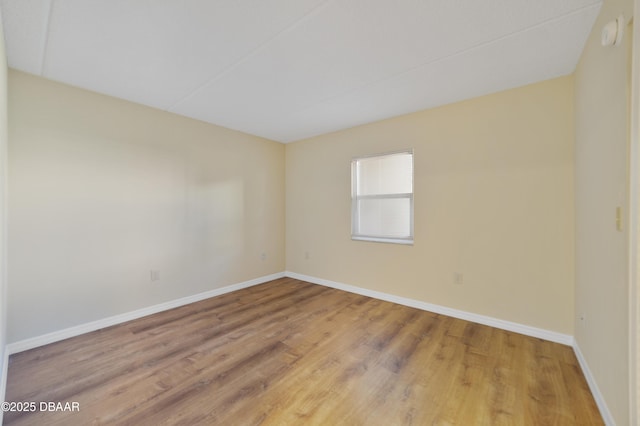 empty room featuring wood finished floors and baseboards